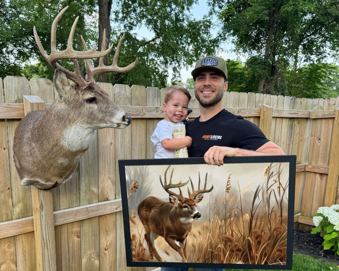 Colby Lawson, owner and operator of Hunt Local Custom Art, holding a framed custom deer art print beside a real shoulder mount